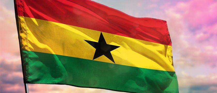 Flag of Ghana against a sunset background
